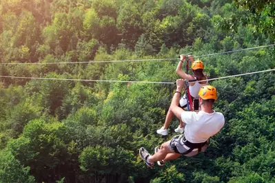 couple ziplining in the mountains