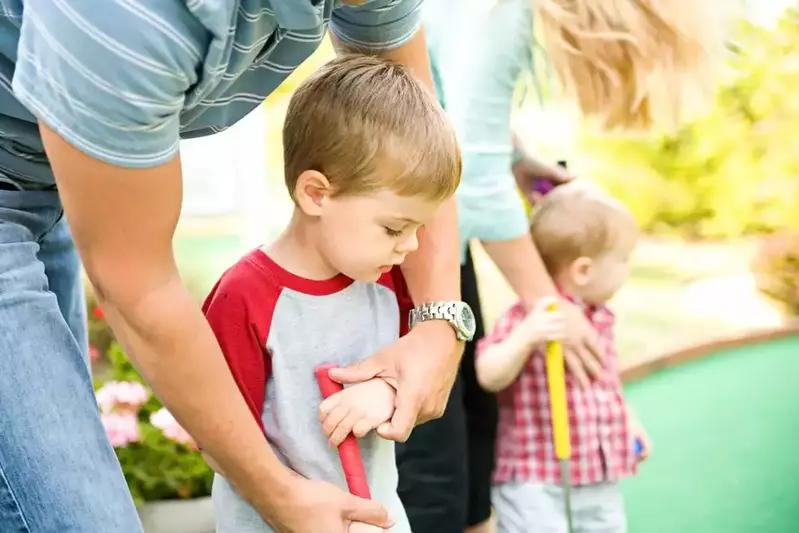 Parents teaching their kids how to play mini golf.