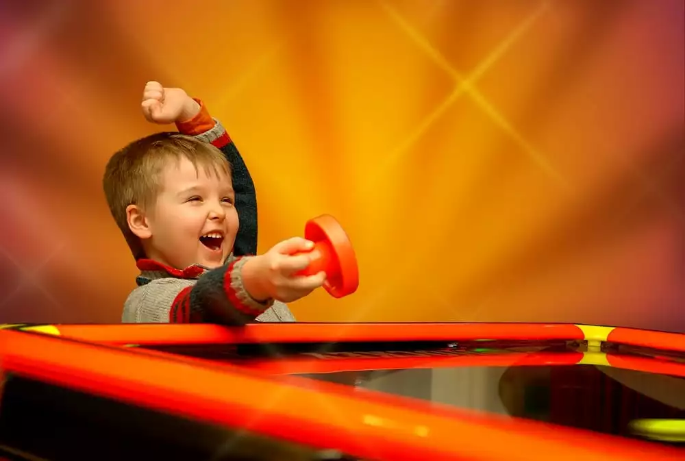 boy playing air hockey