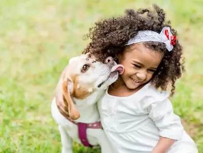 young girl with dog licking her face at pet friendly cabin in Gatlinburg TN