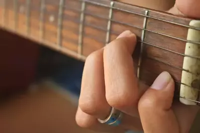 Female_hand_playing_acoustic_guitar