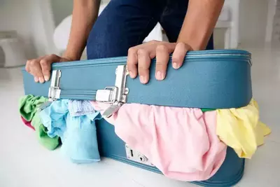 suitcase overflowing with clothes
