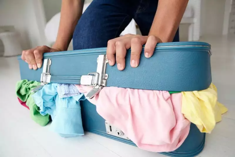 suitcase overflowing with clothes