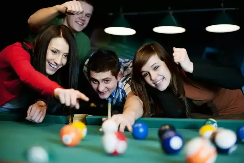 friends playing pool in cabin