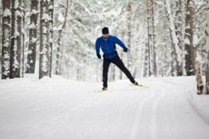 A_man_cross-country_skiing_in_the_forest