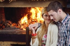 Couple sitting by the fireplace in a Gatlinburg Cabin