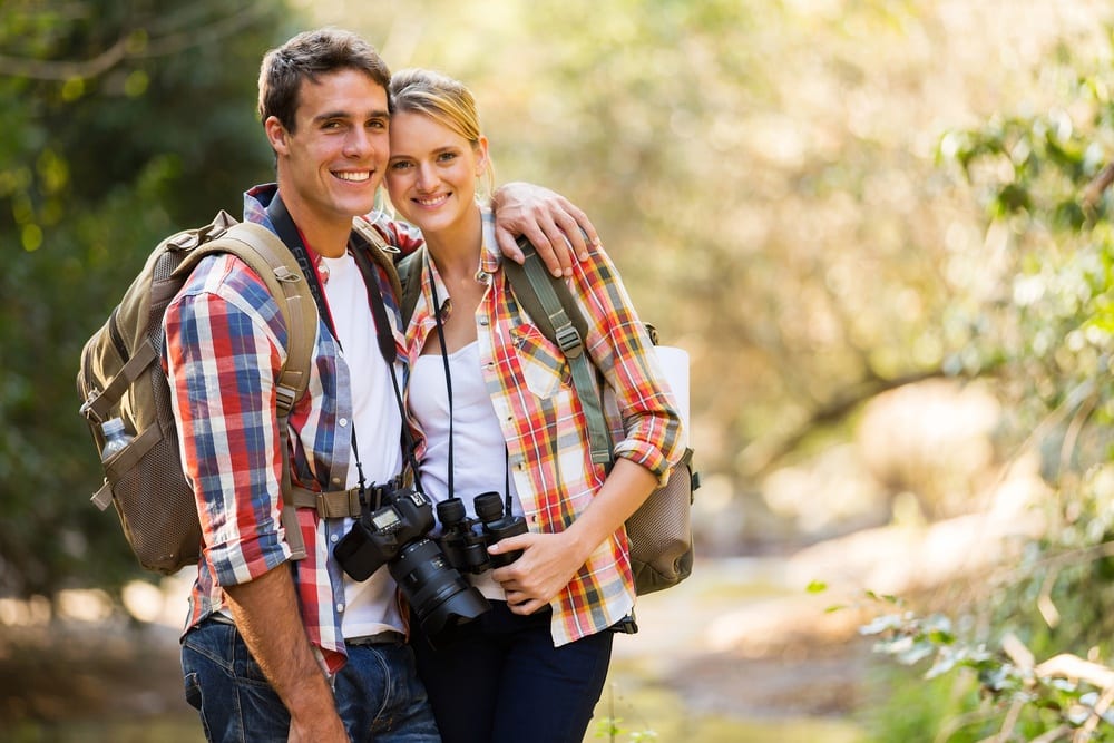 Young couple with backpacks and binoculars on a hike in the Smoky Mountains