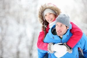 Happy_couple_hiking_in_the_woods_on_a_snowy_day