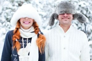 A couple with hats pulled over their faces in the snow in the Smoky Mountains