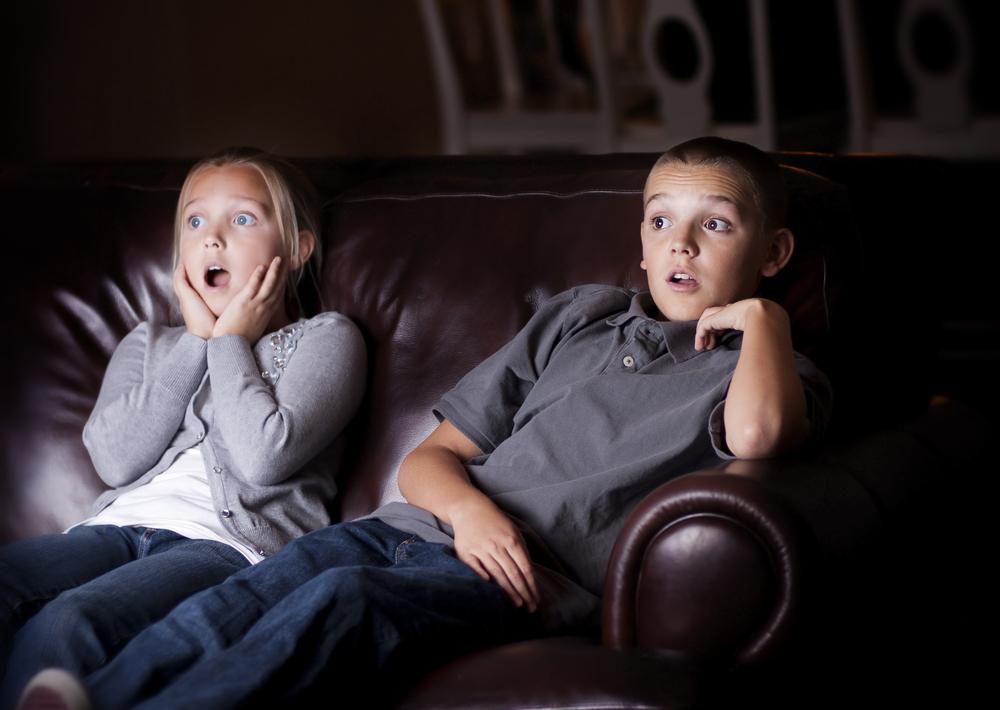two young children watching shocking movie in a Gatlinburg cabin rental