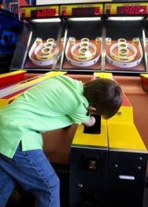 boy-playing-skee-ball-in-arcade